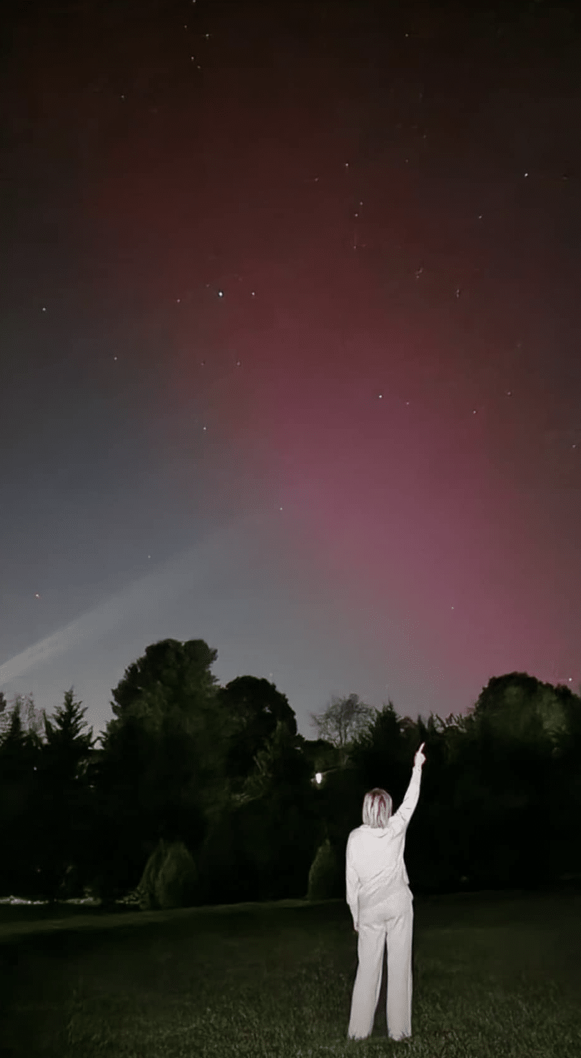 Tania Stephens pointing at the Northern Lights